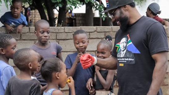 Lovemore Ndou (right) engages with children while on the campaign trail in South Africa
