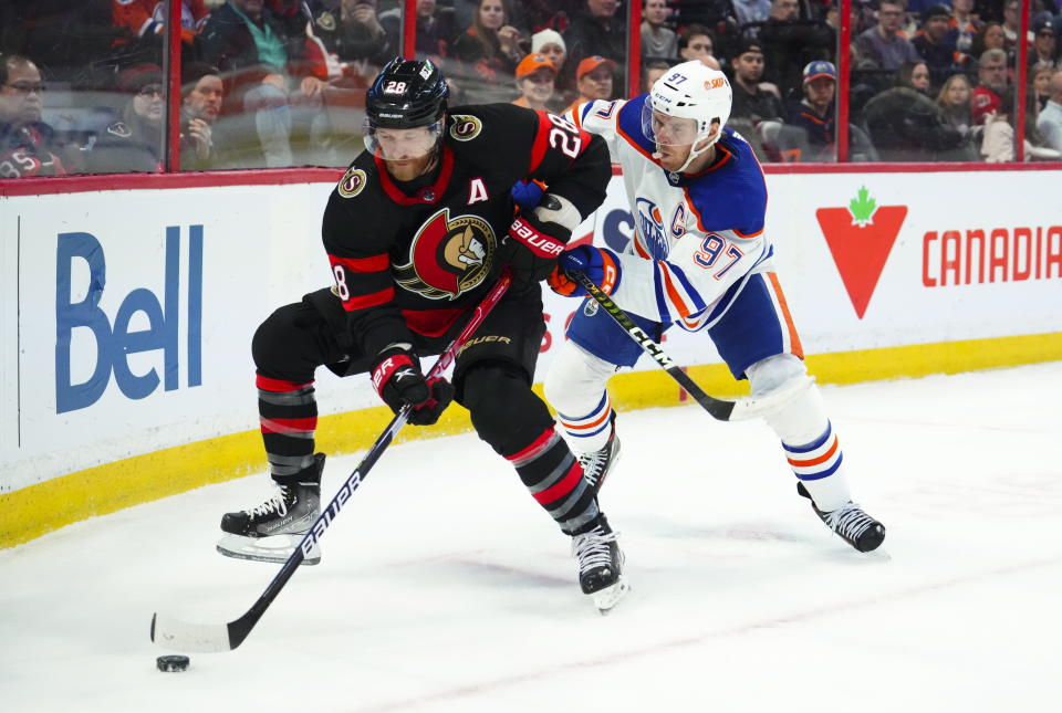 Edmonton Oilers center Connor McDavid (97) tries to push Ottawa Senators right wing Claude Giroux (28) off the puck during the second period of an NHL hockey game in Ottawa on Saturday, Feb. 11, 2023. (Sean Kilpatrick/The Canadian Press via AP)