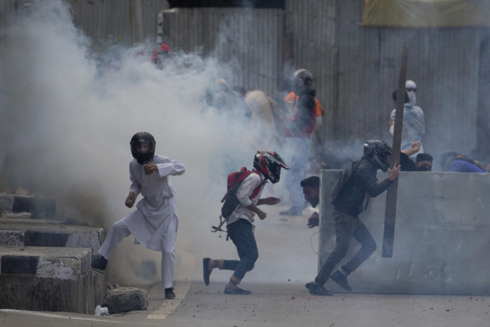 FILE- In this May 31, 2019 file photo, Kashmiri protesters clash with Indian police men in Srinagar, Indian controlled Kashmir. For decades a separatist movement has fought Indian rule in Kashmir, which is split between Pakistan and India and claimed by both in its entirety. Some 70,000 people have died in clashes between militants and civilian protesters and Indian security forces since 1989. (AP Photo/Dar Yasin, File)