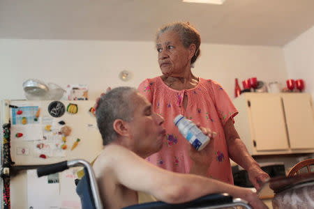 Juanita Gomez Cruz caresses her son Dafner who is disabled, at their home in San Juan, Puerto Rico, November 15, 2016. REUTERS/Alvin Baez