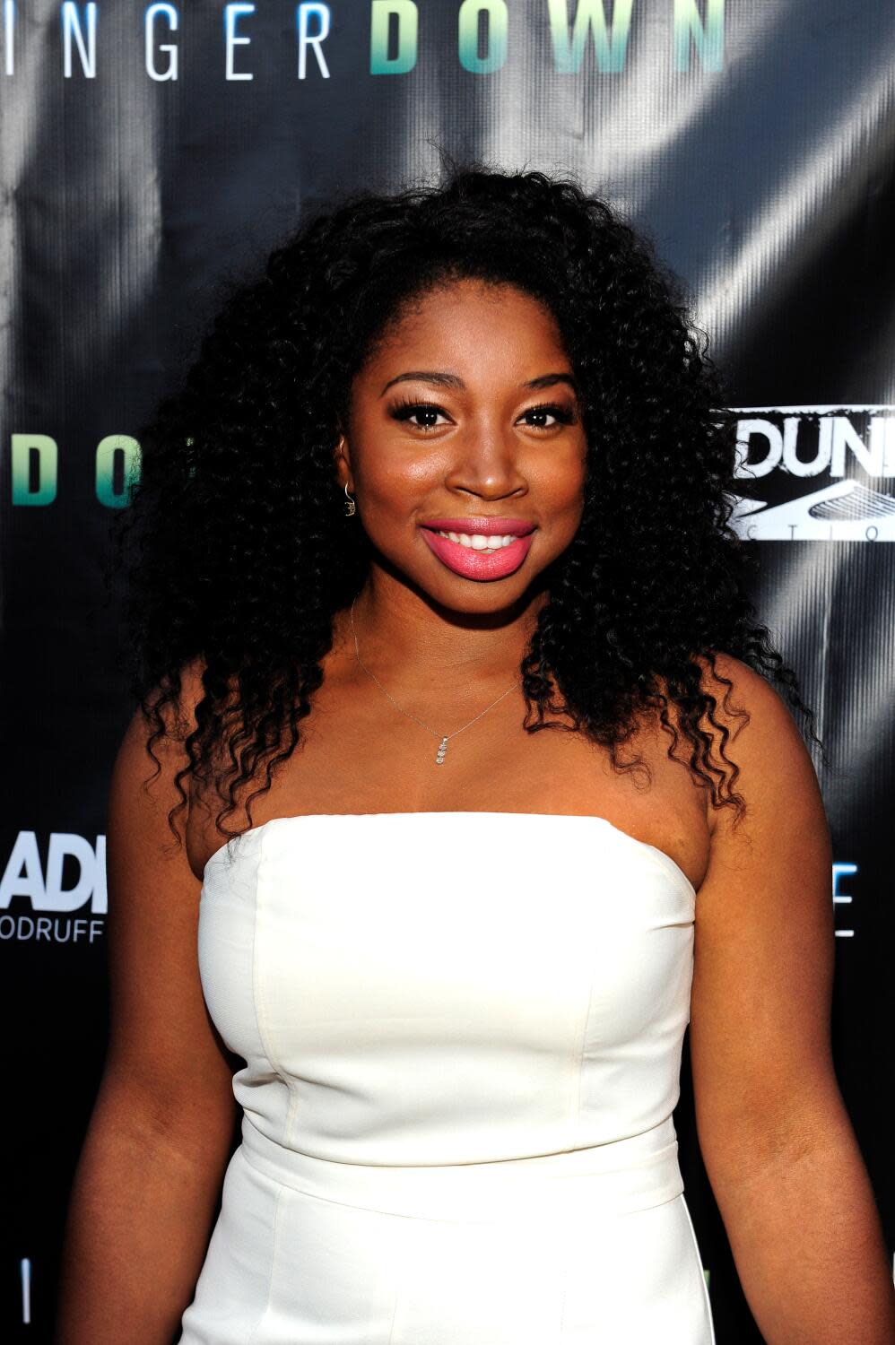 Giovonnie Samuels wears a white strapless dress and pink lipstick.