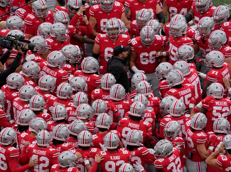 Ohio State coach Ryan Day huddles with his players before facing Maryland.