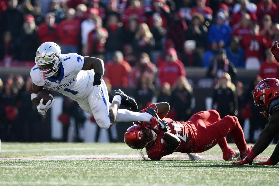 Kentucky running back Ray Davis (1) is brought down by Louisville linebacker Jaylin Alderman (24) during the second half of an NCAA college football game in Louisville, Ky., Saturday, Nov. 25, 2023. Kentucky won 38-31. (AP Photo/Timothy D. Easley)