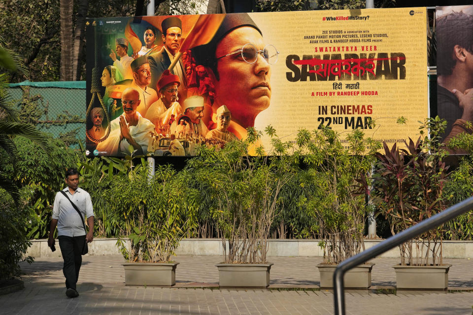 A man walks past a large poster of the movie Swatantra Veer Savarkar displayed outside a cinema hall in Mumbai, India, Thursday, Mar. 21, 2024. The movie, set to be released on Friday, is one of several upcoming Bollywood releases based on polarizing issues, which either promote Indian Prime Minister Narendra Modi and his government’s political agenda, or lambast his critics. (AP Photo/Rajanish Kakade)