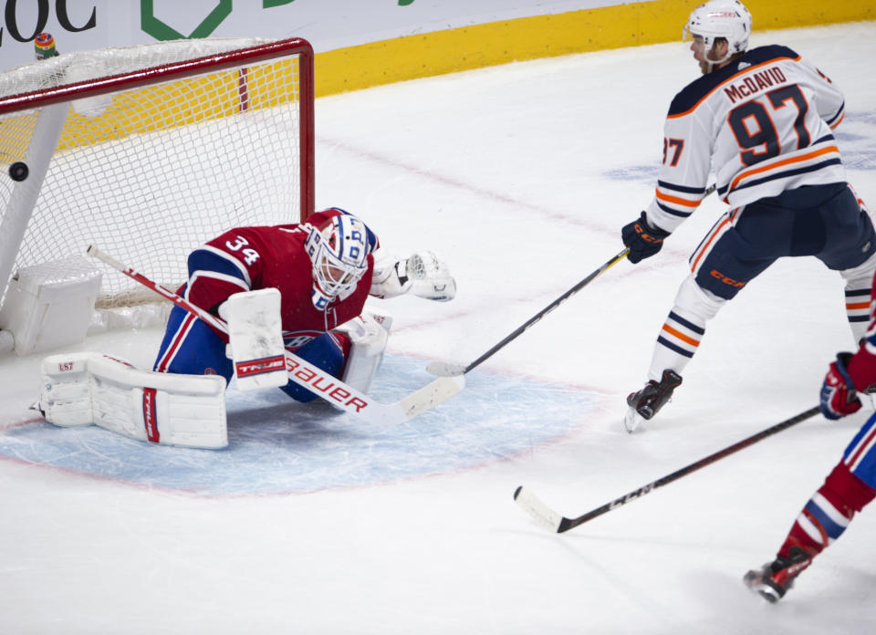 Edmonton Oilers' Connor McDavid (97) scores the winning goal on Montreal Canadiens goaltender Jake Allen (34) during overtime of an NHL hockey game in Montreal, Monday, May 10, 2021. (Ryan Remiorz/The Canadian Press via AP)