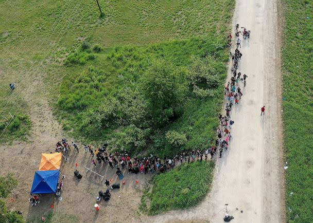 PHOTO: In this aerial view, migrants stand in line as they wait to be processed by the U.S. Border Patrol after crossing the border from Mexico on May 10, 2023, in Brownsville, Texas. (Joe Raedle/Getty Images)