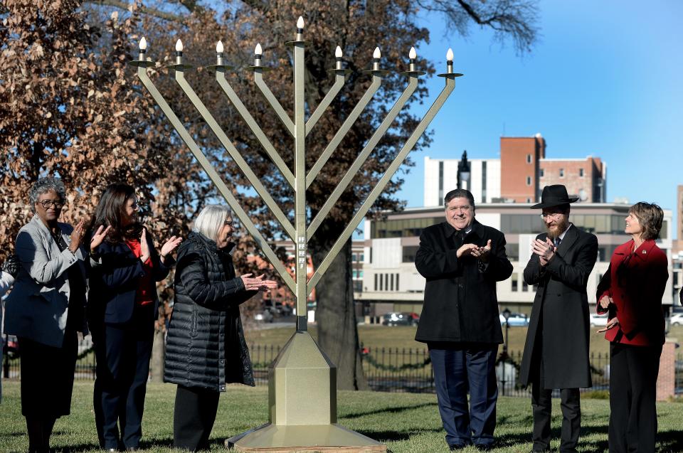 Illinois Gov. JB Pritker, center, right applauds after the state menorah is lit on the grounds of the governor's mansion in Springfield on Thursday.