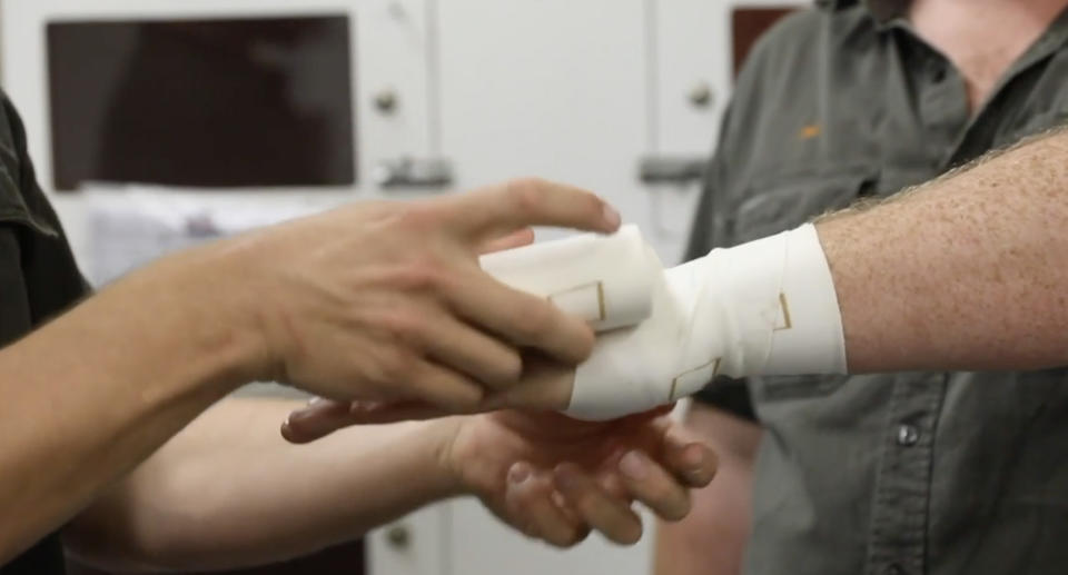 A person having their arm bandaged.