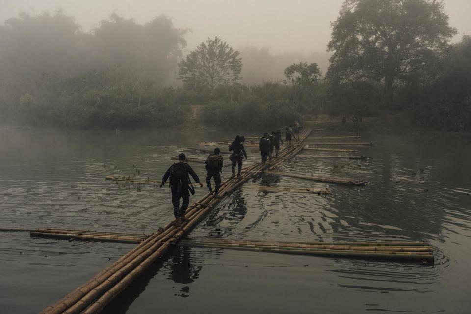 The rangers cross a bamboo bridge in the remote Karen State. It takes days of hiking through the jungle to reach villages in need.