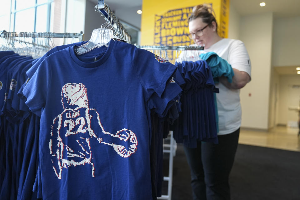 Samantha Halsema looks over Caitlin Clark merchandise in the Indiana Fever team store in Indianapolis, Tuesday, April 16, 2024. The Fever selected Clark Clark as the No. 1 overall pick in the WNBA basketball draft. (AP Photo/Michael Conroy)