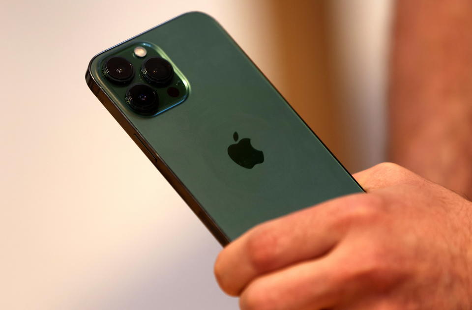 A customers holds the new green colour Apple iPhone 13 pro shortly after it went on sale inside the Apple Store on 5th Avenue in Manhattan in New York City, New York, U.S., March 18, 2022. REUTERS/Mike Segar
