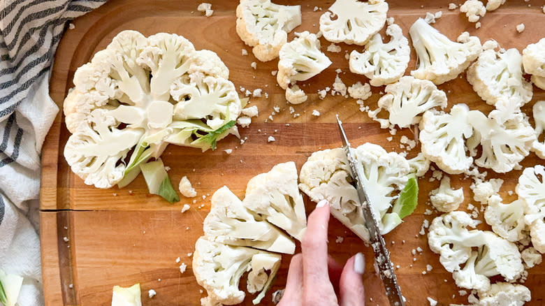 knife cutting cauliflower piece