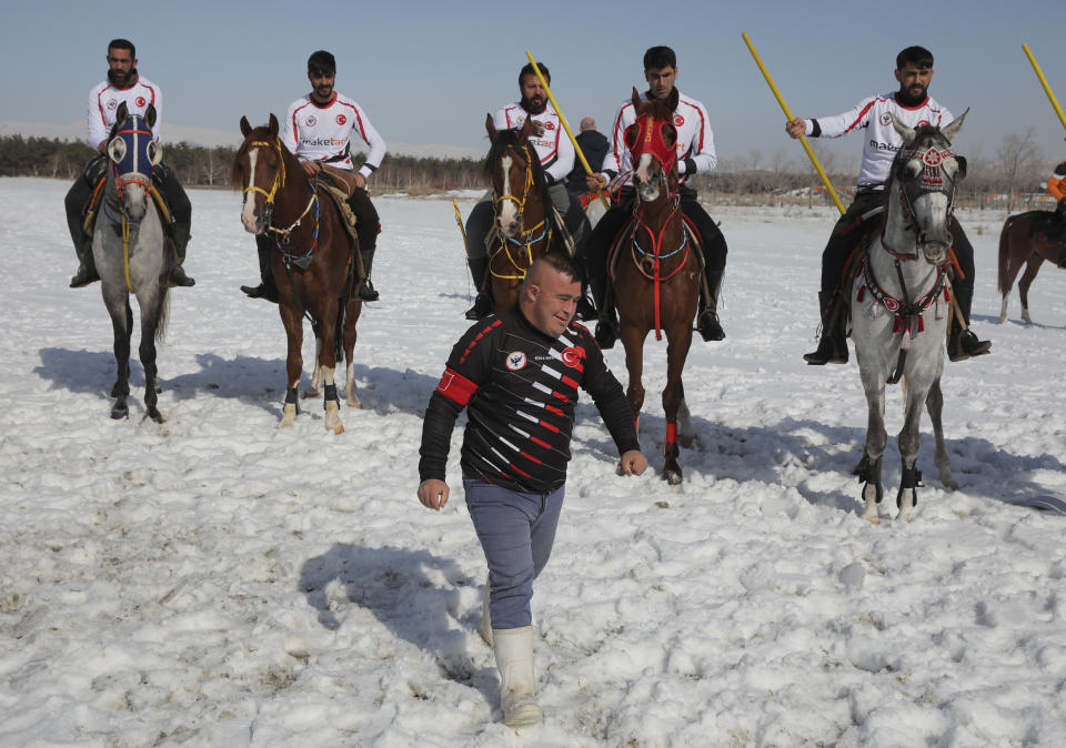 Selcuk Davulcu, 31, a horse groom for the Dadas (Comrades) local sporting club, leaves the ground prior to a game of Cirit, a traditional Turkish equestrian sport that dates back to the martial horsemen who spearheaded the historical conquests of central Asia's Turkic tribes, between the Comrades and the Experts local sporting clubs, in Erzurum, eastern Turkey, Friday, March 5, 2021. The club officials said that Davulcu, a man with Down syndrome has been communicating with people just for the last four years thanks to the horses as they played a big role on his rehabilitation.The game that was developed more than a 1,000 years ago, revolves around a rider trying to spear his or her opponent with a "javelin" - these days, a rubber-tipped, 100 centimeter (40 inch) length of wood. A rider from each opposing team, which can number up to a dozen players, face each other, alternately acting as the thrower and the rider being chased. Cirit was popular within the Ottoman empire, before it was banned as in the early 19th century. (AP Photo/Kenan Asyali)