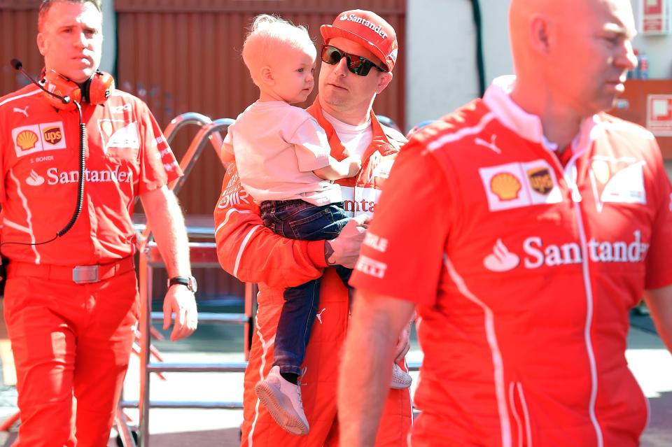 Ferrari's Finnish driver Kimi Raikkonen (2ndR) holds his son Robin in his arms at the Circuit de Catalunya on March 10, 2017 in Montmelo on the outskirts of Barcelona on the fourth day of the second week of tests ahead of the Formula One Grand Prix season. / AFP PHOTO / LLUIS GENE        (Photo credit should read LLUIS GENE/AFP via Getty Images)