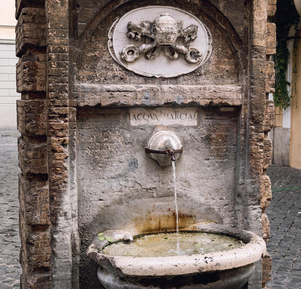 Old traditional drinking fountain with cold water in Rome