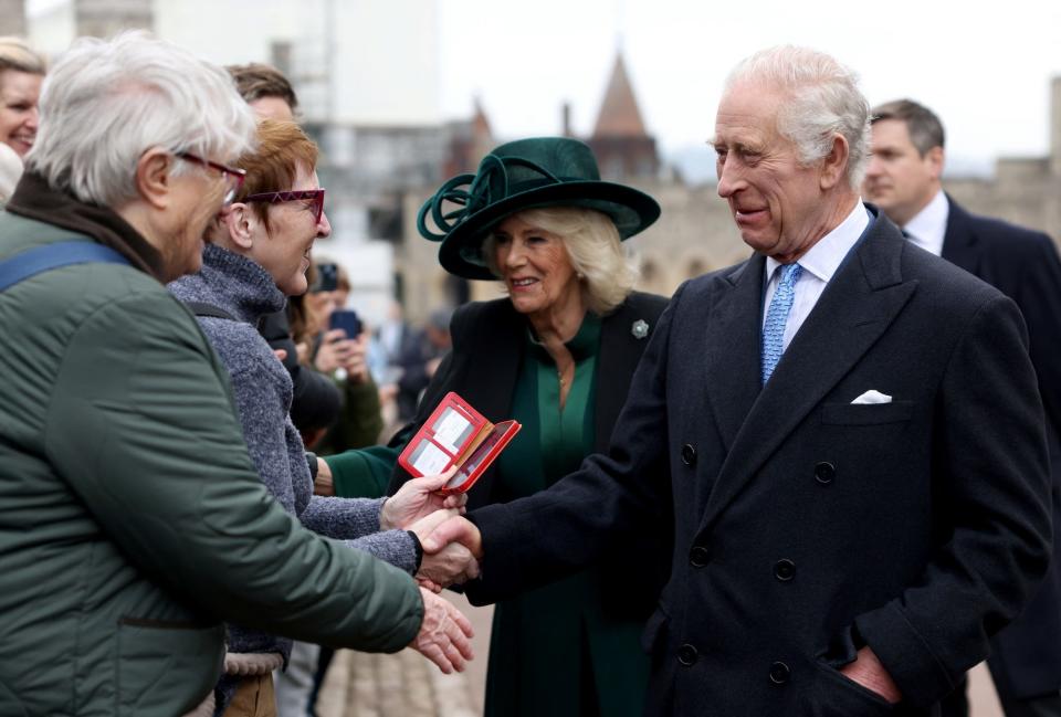 King Charles and Queen Camilla shake hands with people at Windsor Castle on Easter 2024.