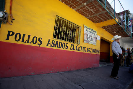 A man smokes outside a restaurant called 'El Chapo', referring to Mexican drug lord Joaquin 'El Chapo' Guzman, ahead of the visit of Mexico's President Andres Manuel Lopez Obrador to Badiraguato, in the Mexican state of Sinaloa, Mexico February 15, 2019. REUTERS/Daniel Becerril