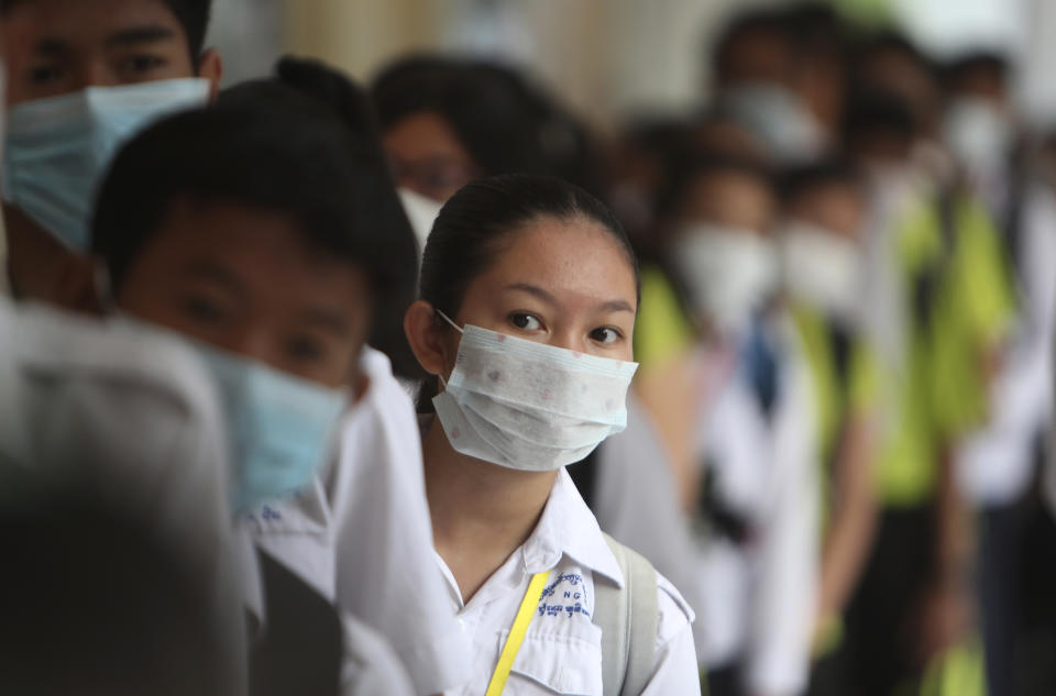 Students line up to sanitize their hands to avoid the contact of coronavirus before their morning class at a hight school in Phnom Penh, Cambodia, Tuesday, Jan. 28, 2020. China on Tuesday reported 25 more deaths from a new viral disease, as the U.S. government prepared to fly Americans out of the city at the center of the outbreak. (AP Photo/Heng Sinith)