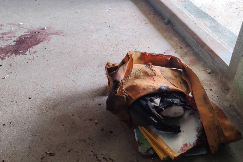 A school bag lies next to dried blood stains on the floor of a middle school in Let Yet Kone village in Tabayin township in the Sagaing region of Myanmar on Saturday, Sept. 17, 2022, the day after an air strike hit the school. The attack killed a number of adults and children, according to a school administrator and volunteers assisting displaced people. (AP Photo)