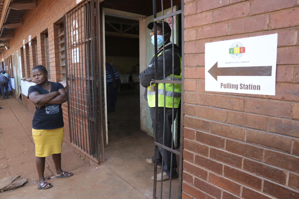 A woman waits outside a polling station in Harare, Wednesday, Aug. 23 2023. Polls have opened in Zimbabwe as President President Emmerson Mnangagwa seeks a second and final term in a country with a history of violent and disputed votes. (AP Photo/Tsvangirayi Mukwazhi)