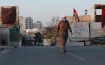 A man walks through an almost empty street during a curfew to help prevent the spread of the coronavirus, in downtown Baghdad, Iraq, Sunday, May 31, 2020. (AP Photo/Hadi Mizban)