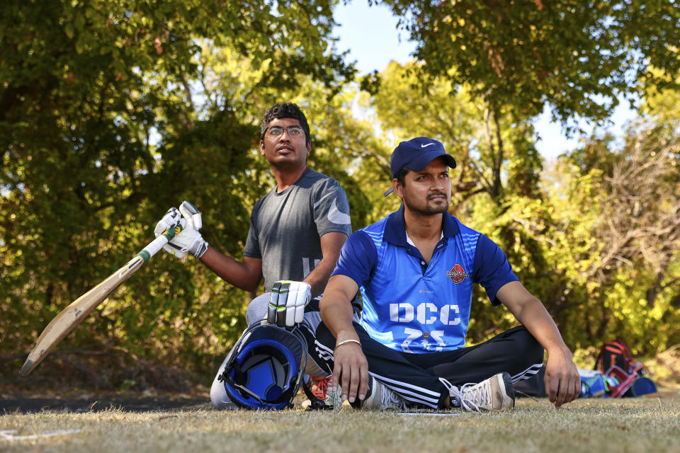 Suresh Bukkara Nagaraju, left, and Satay Das watch play from the sideline during a cricket match between the Dallas Cricket Connections and the Kingswood Cricket Club on a field adjacent to Roach Middle School in Frisco, Texas, Saturday, Oct. 22, 2022. The teams play in the City of Frisco Cricket league. (AP Photo/Andy Jacobsohn)