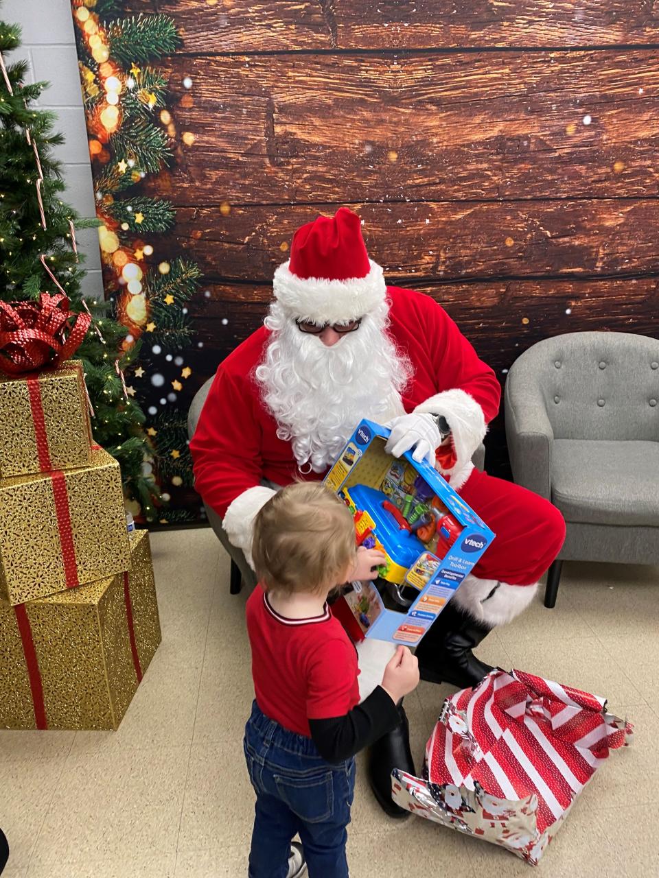 Santa Claus gives a gift during Fostering Hope Together's annual Breakfast with Santa event, held Dec. 18.