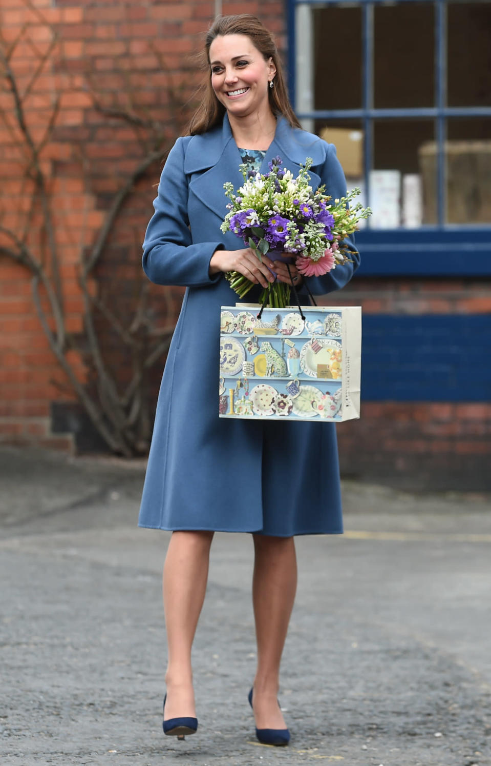 <p>Kate opted for an elegant blue Max Mara coat for a trip to a pottery factory in Staffordshire. The Duchess accessorised with a navy clutch from L.K. Bennett and suede heels by Jimmy Choo. </p><p><i>[Photo: PA]</i></p>