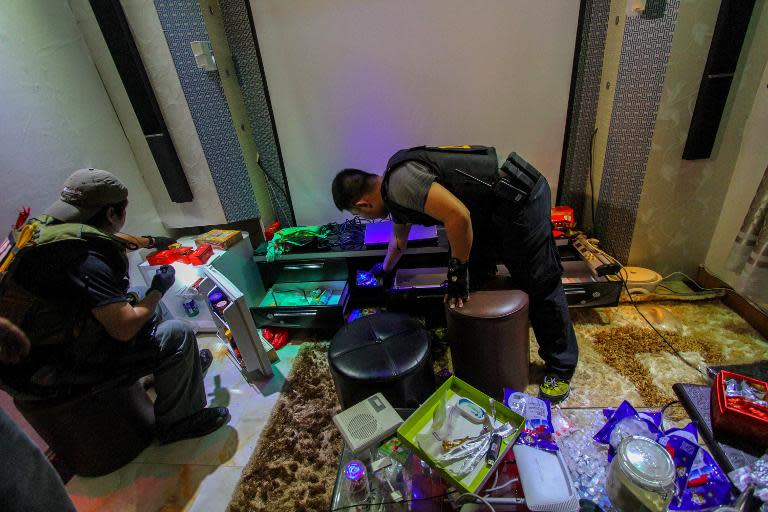 National Bureau of Investigation operatives inspect confiscated materials prohibited inside the New Bilibid Prison in Muntinlupa, south of Manila on December 16, 2014
