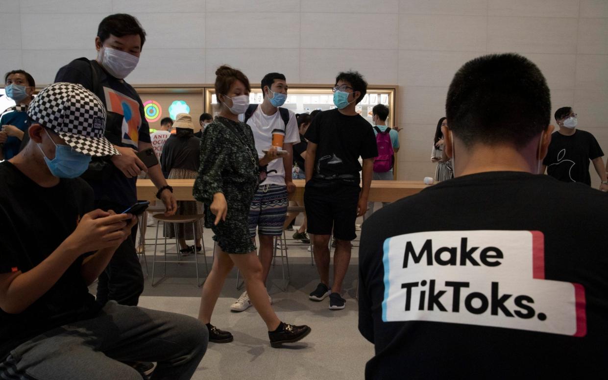 A visitor to an Apple store wears a T-shirt promoting Tik Tok in Beijing. Nigel Inkster, a former intelligence and operations director at the UK's Secret Intelligence Service, said the Beijing-owned app could serve as an “entry-point” for Chinese hackers - Ng Han Guan/AP