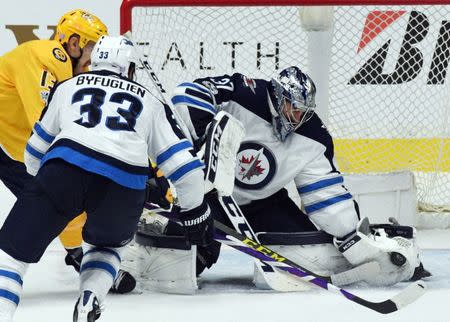 Nov 20, 2017; Nashville, TN, USA; Winnipeg Jets goalie Connor Hellebuyck (37) makes a save on a shot by Nashville Predators center Nick Bonino (13) during the second period at Bridgestone Arena. Christopher Hanewinckel-USA TODAY Sports