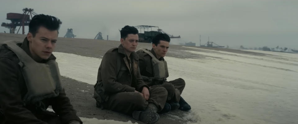 three soldiers sit on a beach