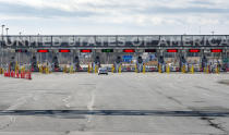 A vehicle approaches the only open lane at the United States border crossing in Lacolle, Quebec, Wednesday, March 18, 2020. The Canada-U.S. border will be closed to non-essential traffic in both directions "by mutual consent," U.S. President Donald Trump confirmed Wednesday, as efforts across the continent to contain the widening COVID-19 pandemic continued to upend daily life in North America. (Ryan Remiorz/The Canadian Press via AP)