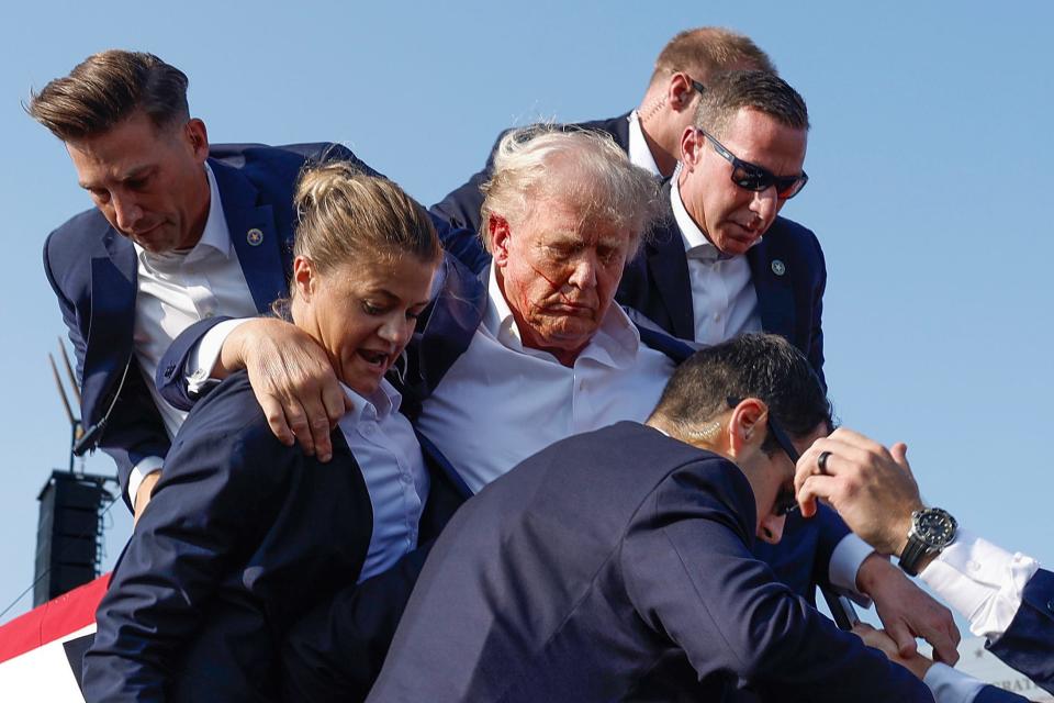 Republican presidential candidate former President Donald Trump is rushed offstage by U.S. Secret Service agents after being grazed by a bullet during a rally on July 13, 2024, in Butler, Pennsylvania. Butler County district attorney Richard Goldinger said the shooter is dead after injuring former U.S. President Donald Trump, killing one audience member and injuring another in the shooting.