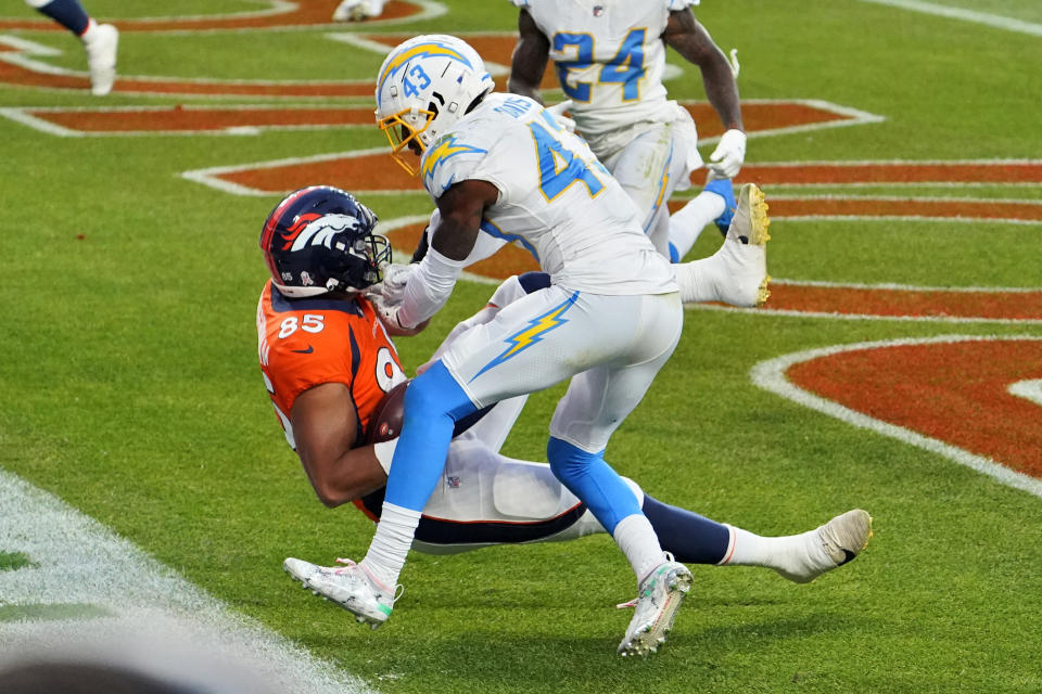 Denver Broncos tight end Albert Okwuegbunam (85) scores a touchdown as Los Angeles Chargers cornerback Michael Davis (43) defends during the second half of an NFL football game, Sunday, Nov. 1, 2020, in Denver. (AP Photo/Jack Dempsey)