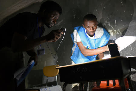 Electoral workers count the votes during a presidential run-off in Freetown, Sierra Leone March 31, 2018. REUTERS/Olivia Acland