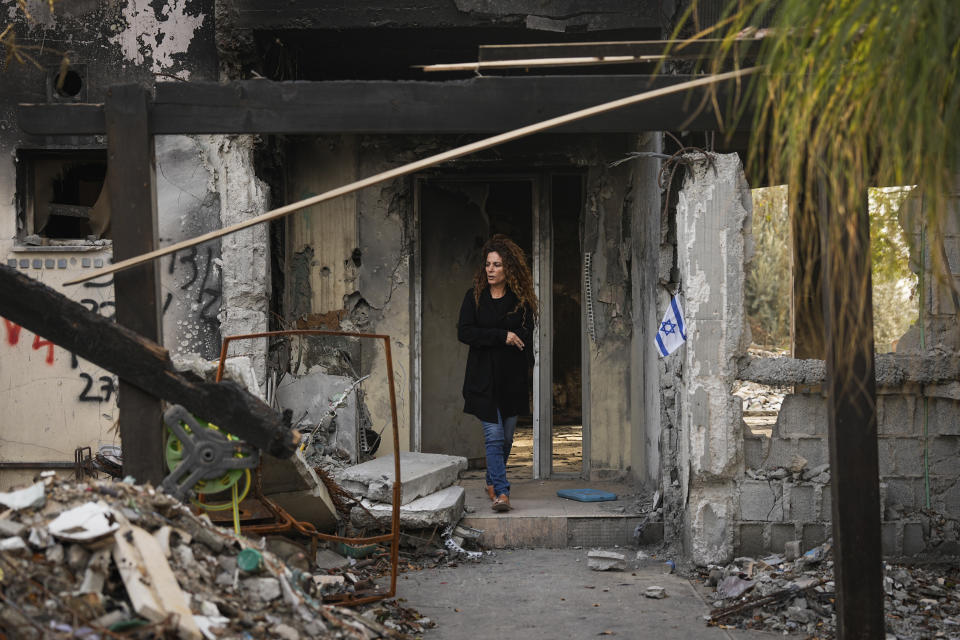 Carmit Dvory, visits the ruins of a house belonging to members of her community in Kibbutz Be'eri, Israel, Wednesday, Dec. 20, 2023. The kibbutz was overrun by Hamas militants from the nearby Gaza Strip on Oct.7, when they killed and captured many Israelis. (AP Photo/Ohad Zwigenberg)
