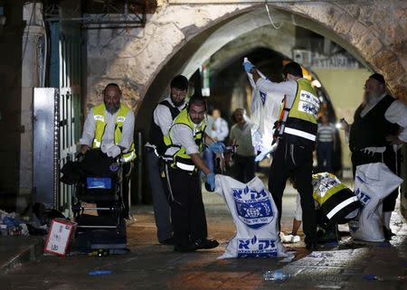 Members of the Zaka Rescue and Recovery team clean the scene where a Palestinian was shot dead after he stabbed and killed two people in Jerusalem's Old City October 3, 2015. REUTERS/Ammar Awad