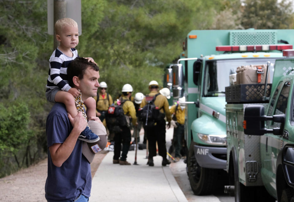 Pacific Palisades resident Mike Sutton, 31, and his son, Tommy, 2, watch the deployment of firefighters at the Palisades Fire in the Pacific Palisades area of Los Angeles, Sunday, May 16, 2021. (AP Photo/Ringo H.W. Chiu)