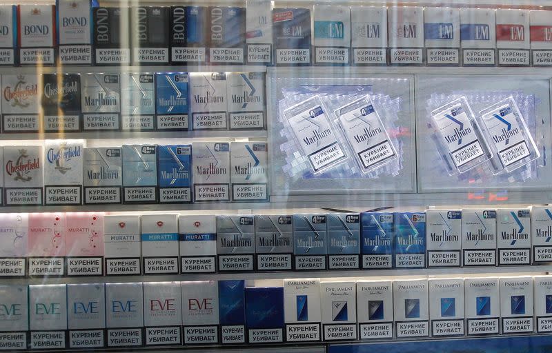 FILE PHOTO: Packs of cigarettes are displayed behind a kiosk window on a street in St. Petersburg