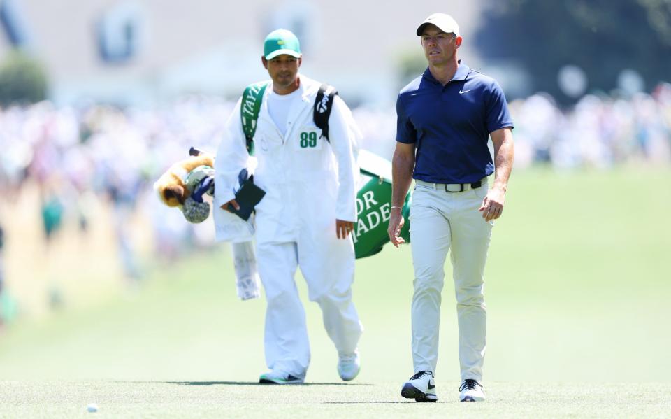 Rory McIlroy walking down the first hole with his caddie