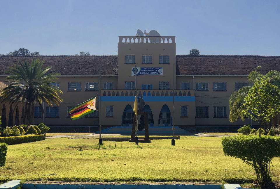 The Zimbabwean flag flies at half mast at Kutama College, a school where former Zimbabwean President Robert Mugabe studied in his rural home in Zvimba about 100 kilometres north west of the capital Harare, Friday, Sept, 27, 2019. Zimbabwe's former presient Robert Mugabe is expected to be buried on Saturday, a family spokesperson said Friday, after three weeks of drama over the former strongman's final resting place.(AP Photo/Tsvangirayi Mukwazhi)