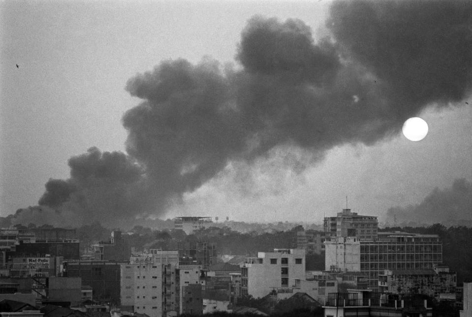 Smoke rises over battle-scarred Saigon during the Tet Offensive as the sun sets over the South Vietnamese capital on Feb. 8, 1968. The Tet Offensive was a campaign launched by Viet Cong and North Vietnamese combatants against South Vietnamese troops and their allies. (AP Photo/Eddie Adams)