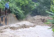 A man looks at flowing water after heavy rain caused flooding in Yalta