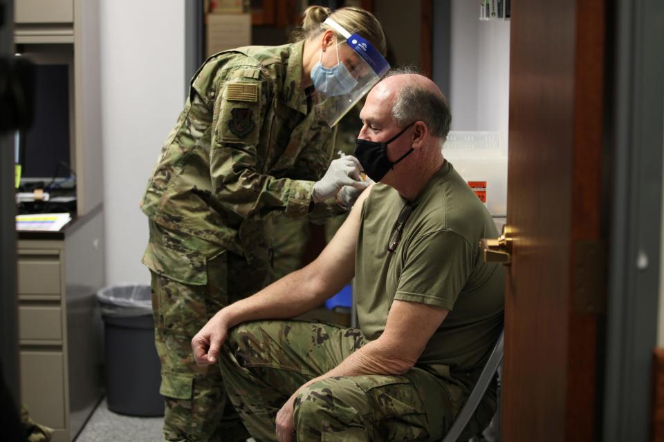 Kansas Air National Guard Maj. Cortney Neblett, left, gives a COVID-19 vaccine shot to Master Sgt. Thomas Lafountain, right, during a clinic for Kansas National Guard personnel, Friday, Feb. 5, 2021, at Air National Guard's base south of Topeka, Kan.