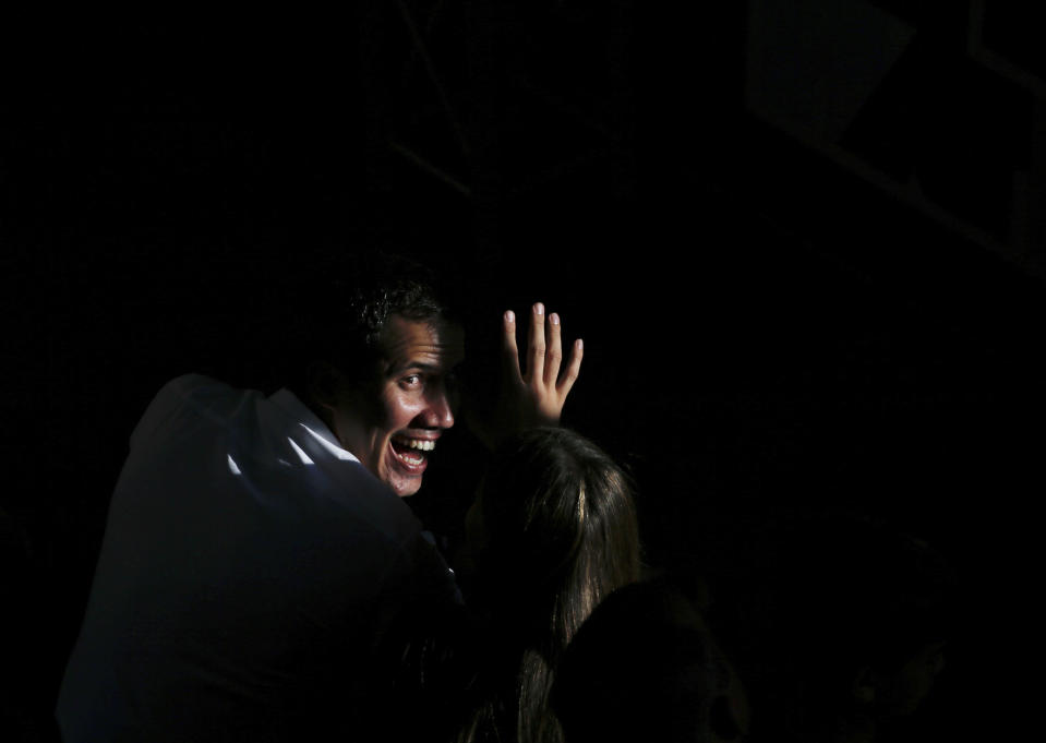 National Assembly President Juan Guaido greets supporters as he arrives to meet with residents in the Hatillo municipality of Caracas, Venezuela, Thursday, March 14, 2019. Guaido has declared himself interim president and demands new elections, arguing that President Nicolas Maduro's re-election last year was invalid. (AP Photo/Fernando Llano)