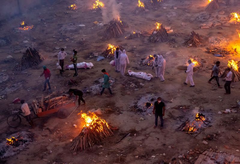 People wait to cremate COVID-19 victims at a crematorium ground in New Delhi