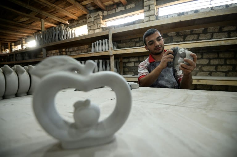 One of Mostafa el-Agoury's employees works on a piece of pottery at Agoury's workshop in Menufiya province on June 21, 2018