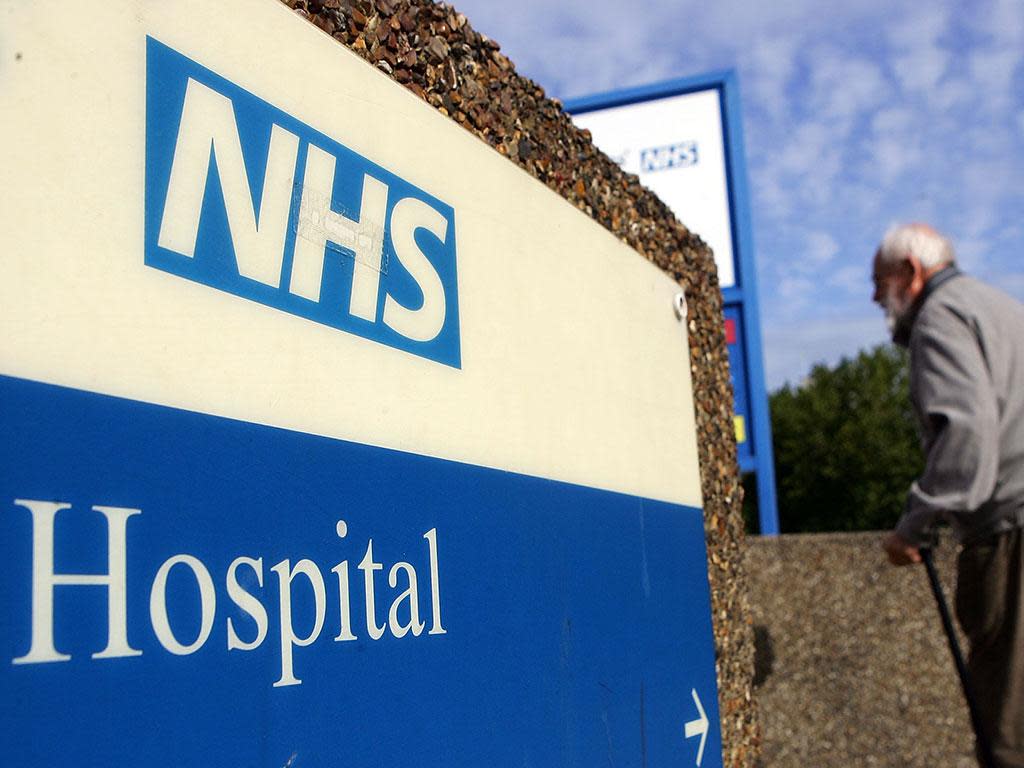 An elderly gentleman walks past a hospital sign: Getty