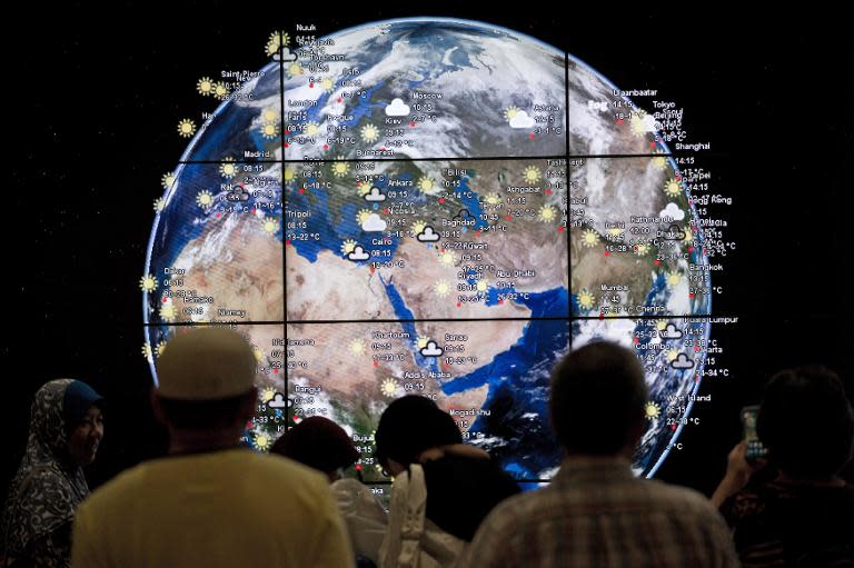 Passengers look at a "digital earth" displayed at Kuala Lumpur International Airport (KLIA) in Sepang, outside Kuala Lumpur on March 16, 2014